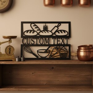 Könnte beinhalten: Schwarzes Holzschild mit Backthema, mit Brot, einem Nudelholz und Backutensilien. Das Schild enthält den Text "CUSTOM TEXT". Eine antike Waage und Kupferschalen sind ebenfalls sichtbar.