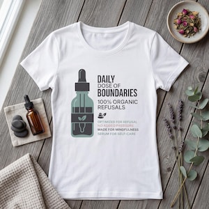 Könnte beinhalten: Weißes T-Shirt mit dem Text "DAILY DOSE OF BOUNDARIES" und einer Grafik einer Tropfflasche. Das Shirt enthält auch den Text "100% ORGANIC REFUSALS" und "SERUM FOR SELF-CARE".