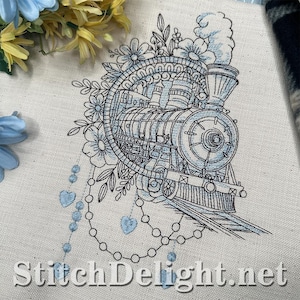 May include: Embroidered design of a vintage steam train in light blue and black. The train is surrounded by floral elements and heart-shaped accents. The text "StitchDelight.net" is at the bottom.
