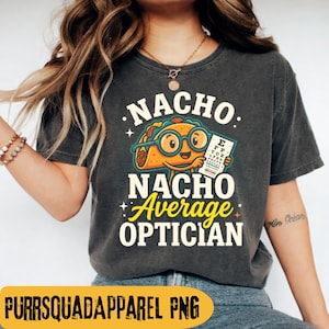 May include: Dark grey t-shirt with the words "NACHO NACHO Average OPTICIAN" in white and yellow. The graphic features a cartoon taco wearing glasses and holding an eye chart. The shirt is a casual style.