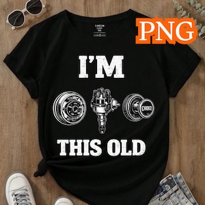 May include: Black t-shirt with the text "I'M THIS OLD" and illustrations of car parts. The shirt features a round wheel, a distributor, and a choke. The design is in white.