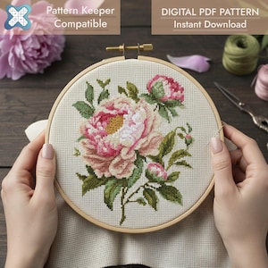 Puede incluir: Un bastidor de bordado de punto de cruz con un diseño floral de peonías rosas y blancas con hojas verdes. El texto "Pattern Keeper Compatible" y "DIGITAL PDF PATTERN Instant Download" son visibles.