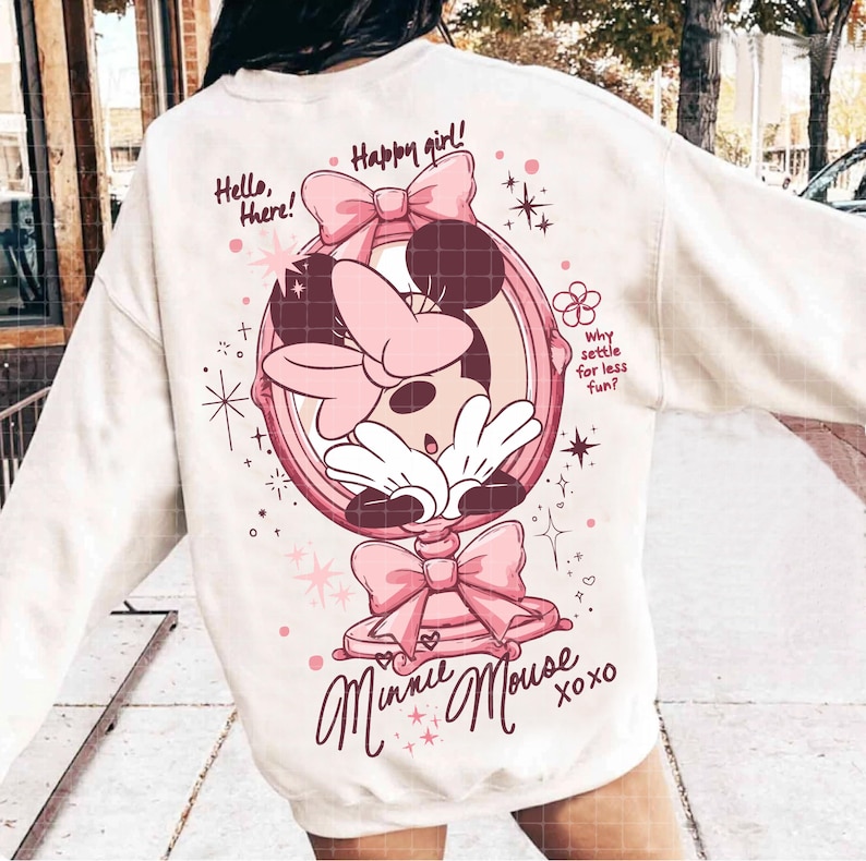 May include: Cream-coloured sweatshirt with a Minnie Mouse graphic in a pink mirror frame. The design includes bows, stars, and the text "Hello, there!" and "Happy girl!" along with "Minnie Mouse xoxo".