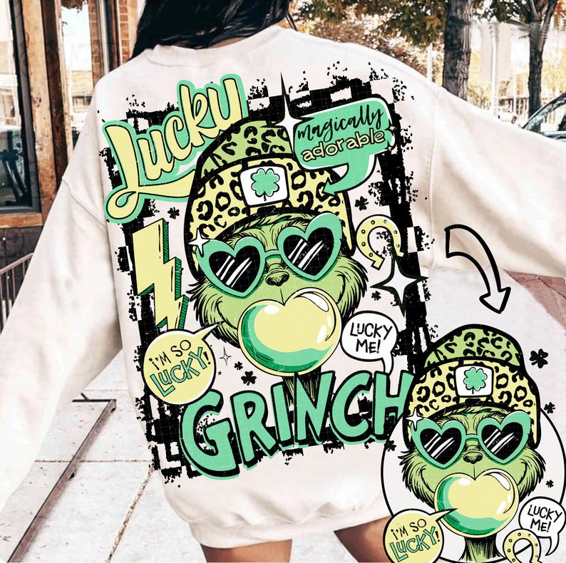 K&ouml;nnte beinhalten: Cremefarbenes Sweatshirt mit einer Grafik eines gr&uuml;nen Grinch-Charakters mit herzf&ouml;rmiger Sonnenbrille und Leopardenmuster-Hut. Text enth&auml;lt "Lucky", "Grinch" und Sprechblasen mit "I'm so lucky!" und "Lucky me!"