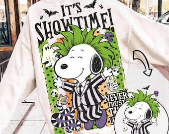 May include: A cream-colored sweatshirt featuring a graphic of a cartoon dog with green hair wearing a black and white striped suit. The text reads IT'S SHOWTIME! and NEVER TRUST THE LIVING. The design includes bats, a ghost, skulls, and a snake.