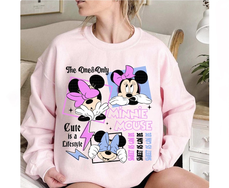 May include: A light pink sweatshirt featuring three Minnie Mouse graphics with bows. The text includes "The One & Only", "Minnie Mouse", and "Cute is a Lifestyle". The design also includes the text "Sweet as Can Be".