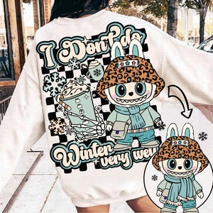 以下が含まれることがあります： 背面に大きなグラフィックがプリントされたクリーム色のスウェットシャツ。ヒョウ柄のバケットハット、水色のスカーフ、バッグを身につけ、飲み物を持ったキャラクターが描かれています。テキストには「I Don't Do Winter very well」と書かれています。