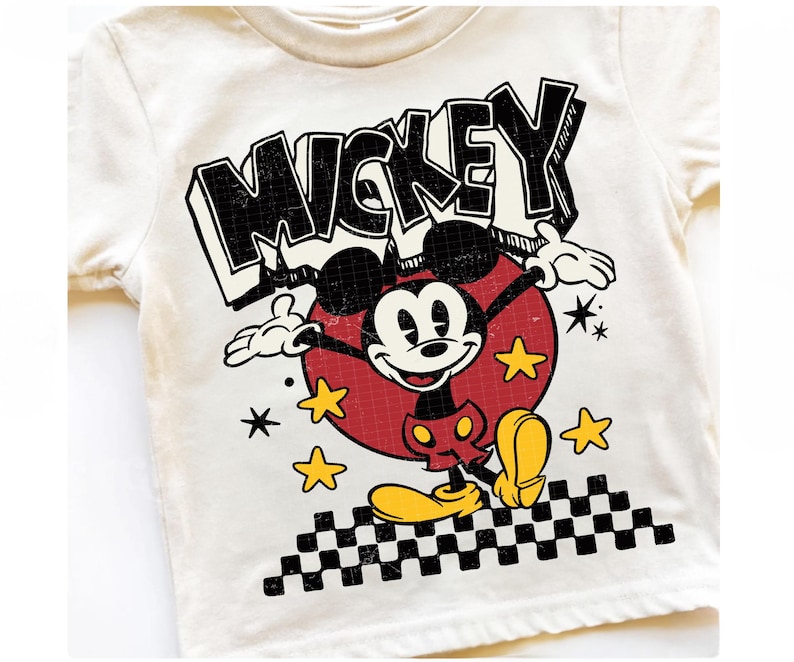 Puede incluir: Camiseta color crema con un dise&ntilde;o de Mickey Mouse de estilo vintage. El dise&ntilde;o incluye la palabra "MICKEY" en letras negras, Mickey Mouse en un c&iacute;rculo rojo, estrellas amarillas y un patr&oacute;n de cuadros blanco y negro.