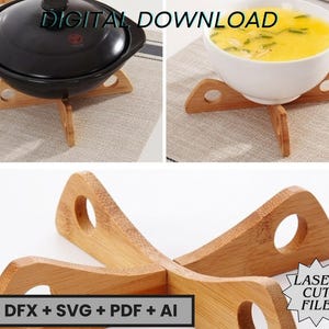 Puede incluir: Salvamanteles de madera con acabado natural, diseñados para sostener platos calientes. Los salvamanteles tienen un diseño de cuatro patas con una abertura circular en cada extremo. Uno sostiene una olla de cerámica negra con tapa, y otro un cuenco blanco con sopa amarilla.