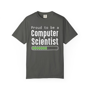 Puede incluir: Camiseta gris oscuro con el texto blanco "Proud to be a Computer Scientist" en fuente pixelada. Un gráfico de barra de carga verde está debajo. Prenda de vestir informal.