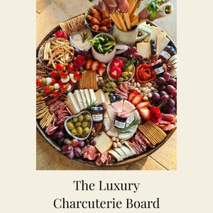 Op de afbeelding: Een grote, ronde charcuterieplank vol met diverse etenswaren. Inclusief kazen, vleeswaren, fruit, crackers, olijven en dips. De plank is visueel aantrekkelijk gepresenteerd. De tekst op de afbeelding luidt "The Luxury Charcuterie Board Lookbook".