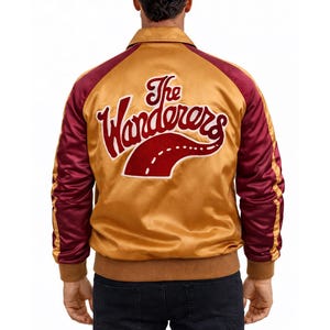 May include: Gold satin jacket with burgundy sleeves and the text "The Wanderers" embroidered on the back. The jacket has a brown collar and cuffs. The design includes a red road graphic.