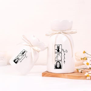 May include: A set of three ceramic mugs with a speckled, matte finish. The mugs are in shades of cream, light gray, and dark gray. Each mug has a simple, minimalist design, perfect for coffee or tea.