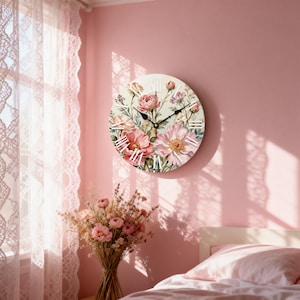 Puede incluir: Un reloj de pared redondo con un diseño floral con flores rosas y melocotón y números romanos. El reloj está montado en una pared rosa. Las manecillas del reloj son negras. Un fondo incluye una cama y cortinas.