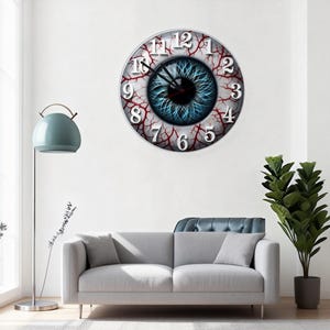 May include: A circular wall clock featuring a blue iris design, encircled by red veins and white numerals. The clock hands are black. The clock is mounted on a white wall above a grey sofa.