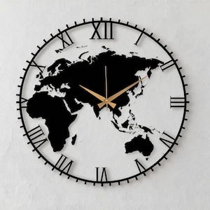 Op de afbeelding: Zwarte en gouden wereldkaart wandklok. De klok heeft een zwart wereldkaart silhouet als wijzerplaat, met gouden wijzers en Romeinse cijfers. De klok is rond en heeft een modern design. Diameter: ongeveer 30 cm.