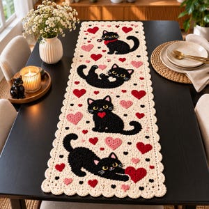 Peut inclure: Un chemin de table rectangulaire en crochet couleur crème orné de quatre chats noirs dans diverses positions, entremêlés de motifs de cœurs rouges et roses. Le chemin présente un bord festonné et de petits points noirs décoratifs.