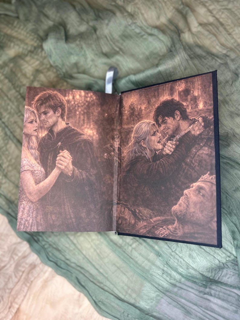 May include: Open book with sepia-toned illustrations. One page shows a couple dancing, the other depicts a dramatic scene with a woman and man embracing, and a fallen figure. A silver bookmark is visible.