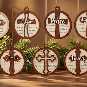 May include: Seven circular wooden ornaments hanging by strings, each featuring a cutout cross design and printed text. The ornaments display words such as Life, Hope, Peace, Gentle, Jesus, and Lover, along with various religious phrases and musical notes.