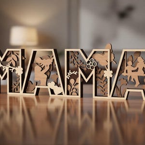Puede incluir: Un letrero de madera cortado con láser que deletrea la palabra MAMA con un acabado marrón claro. Cada letra presenta intrincados recortes de patrones florales, mariposas y siluetas de un padre y un hijo, incluido un niño en un columpio.