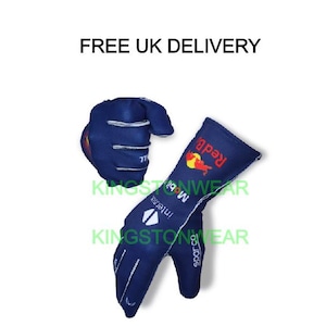 Peut inclure: Deux gants de course bleus marine avec des détails blancs. L'un des gants est posé à plat, l'autre est positionné au-dessus. Les gants arborent le logo Red Bull et des logos de sponsors. Le texte "FREE UK DELIVERY" est en haut.