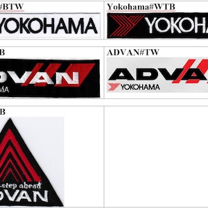 Puede incluir: Una colección de cinco parches bordados con los logotipos de Yokohama y Advan. Los parches incluyen diseños rectangulares en colores negro, blanco y rojo, y un parche triangular negro con rayas rojas y el texto Get a step ahead ADVAN.