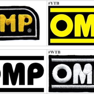 May include: A collection of four rectangular embroidered patches featuring the OMP logo. The top left patch is black with yellow text and a silver border. The top right is black with yellow text and bars. The bottom left is white with black text and bars. The bottom right is black with white text and bars.