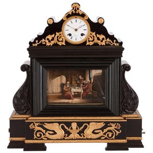 May include: A black mantel clock with gold detailing and a round clock face. The clock features a painting of people in a room. The clock has ornate carvings and a decorative base with gold swan-like figures.