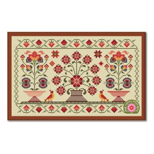 Peut inclure: Un sampler au point de croix encadré avec un motif floral aux fleurs rouges, bleues et jaunes. Deux oiseaux sont placés sous les fleurs. Le sampler a un fond crème et un cadre marron.