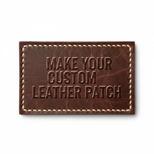 Puede incluir: Un parche rectangular de cuero marrón con el texto en relieve "MAKE YOUR CUSTOM LEATHER PATCH". El parche tiene un borde cosido con hilo color crema. El cuero tiene un aspecto texturizado.