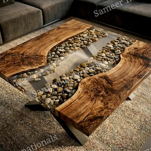 May include: A square coffee table featuring two thick slabs of natural wood with prominent grain patterns, separated by a central channel filled with smooth, multi-colored river stones encased in a clear, transparent resin material.