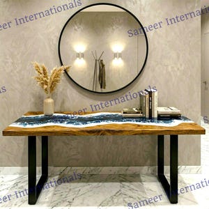 May include: A handmade wooden sign with the text "Welcome to our home" in a handwritten style. The sign is painted white with a dark stained frame. A small, decorative heart is in the bottom right corner.