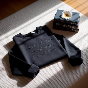 May include: A set of three ceramic mugs with a speckled, matte finish. The mugs are in shades of cream, light gray, and dark gray. Each mug has a simple, modern design and a rounded handle. The mugs are likely for coffee or tea.