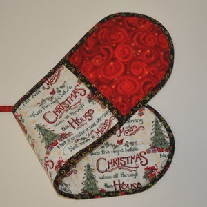 Pode incluir: Um par de luvas de forno natalinas vermelhas e brancas com acabamento preto. As luvas apresentam o texto "Twas the night before Christmas when all through the house... Not a creature was stirring, not even a mouse."