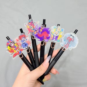 6er Pack Cartoon Zirkus Charakter Stifte mit 10 Nachfüllungen, niedliche Acryl-Topper schwarze Tinte Stifte, Fan inspiriertes Schreibwaren Geschenkset