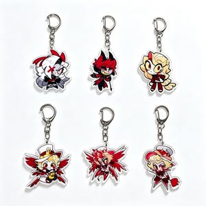 May include: Six acrylic keychains featuring stylised cartoon characters with vibrant red, white, and blonde colour palettes. Each charm is attached to a silver-toned metal lobster clasp and chain, displaying unique character designs with expressive faces.