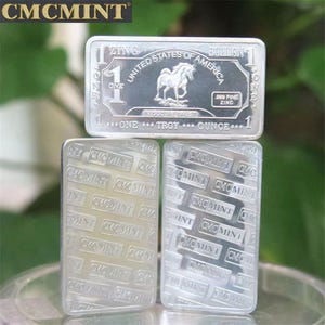 Op de afbeelding: Zilveren zinkstaven. De bovenste staaf toont de tekst "United States of America" en een paardenafbeelding. De staven zijn gemarkeerd met "One Troy Ounce" en "999 Fine Zinc". De onderste staven hebben een herhaald "CMCMINT" patroon.