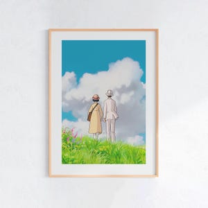 Puede incluir: Una impresión artística enmarcada que presenta a una pareja animada de pie en una colina cubierta de hierba, tomados de la mano y mirando un cielo nublado. La obra de arte tiene una paleta de colores suaves y un marco marrón claro.