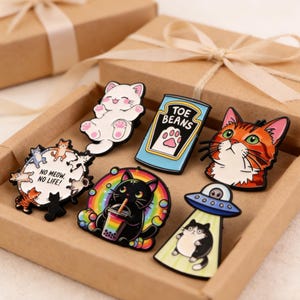 May include: A white ceramic mug with a black handle and the text "But First, Coffee" in a black, handwritten-style font. The mug is on a white surface.