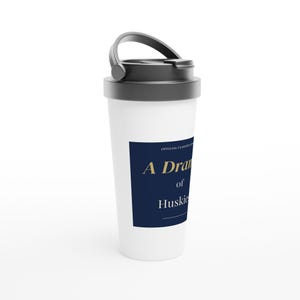May include: White travel mug with a black lid and handle. A navy blue label displays the text "A Dram of Huskies" in gold lettering. The mug is designed for beverages and features a secure lid for portability.