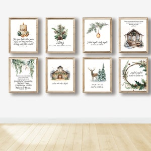 May include: Eight framed watercolor prints with Christmas themes. Each print features a wooden frame and a different design, including candles, pine branches, a deer, and text. The prints are displayed on a white wall.