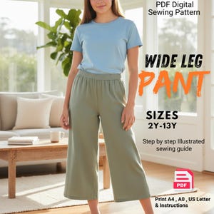 May include: A PDF digital sewing pattern for wide leg pants in sizes 2Y-13Y. The image features a light blue t-shirt and sage green wide leg pants, with text stating "WIDE LEG PANT", "SIZES 2Y-13Y", "Step by step Illustrated sewing guide", and "Print A4, A0, US Letter & Instructions".