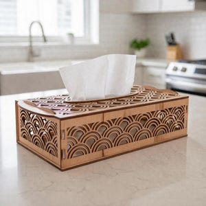 May include: A rectangular wooden tissue box with a decorative, laser-cut wave pattern. The box is made of light-colored wood and holds a stack of white tissues. The design adds a touch of elegance to any room.