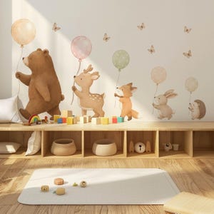 May include: A set of wall decals featuring a brown bear, a deer, a fox, a rabbit, and a hedgehog, each holding a polka-dot balloon. The scene includes several small butterflies scattered above the animals, all rendered in a soft, watercolour style.