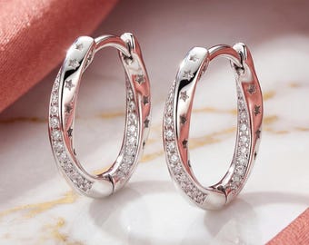 Pendientes de aro trenzados con forma de estrella en plata de ley y circonitas pavé. Joyas para mujer.