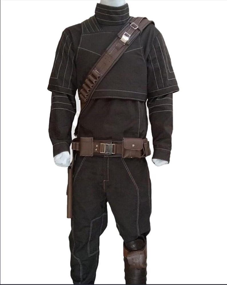 May include: Black costume with a high collar, shoulder strap, and belt with pouches. The outfit includes a long-sleeved top, trousers, and knee-high boots. White stitching details the seams. The costume is displayed on a mannequin.