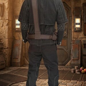 May include: Black tactical outfit with white stitching. The outfit includes a short-sleeved jacket, trousers, and a brown belt and shoulder strap. The jacket features geometric patterns on the sleeves. Suitable for costume or cosplay.