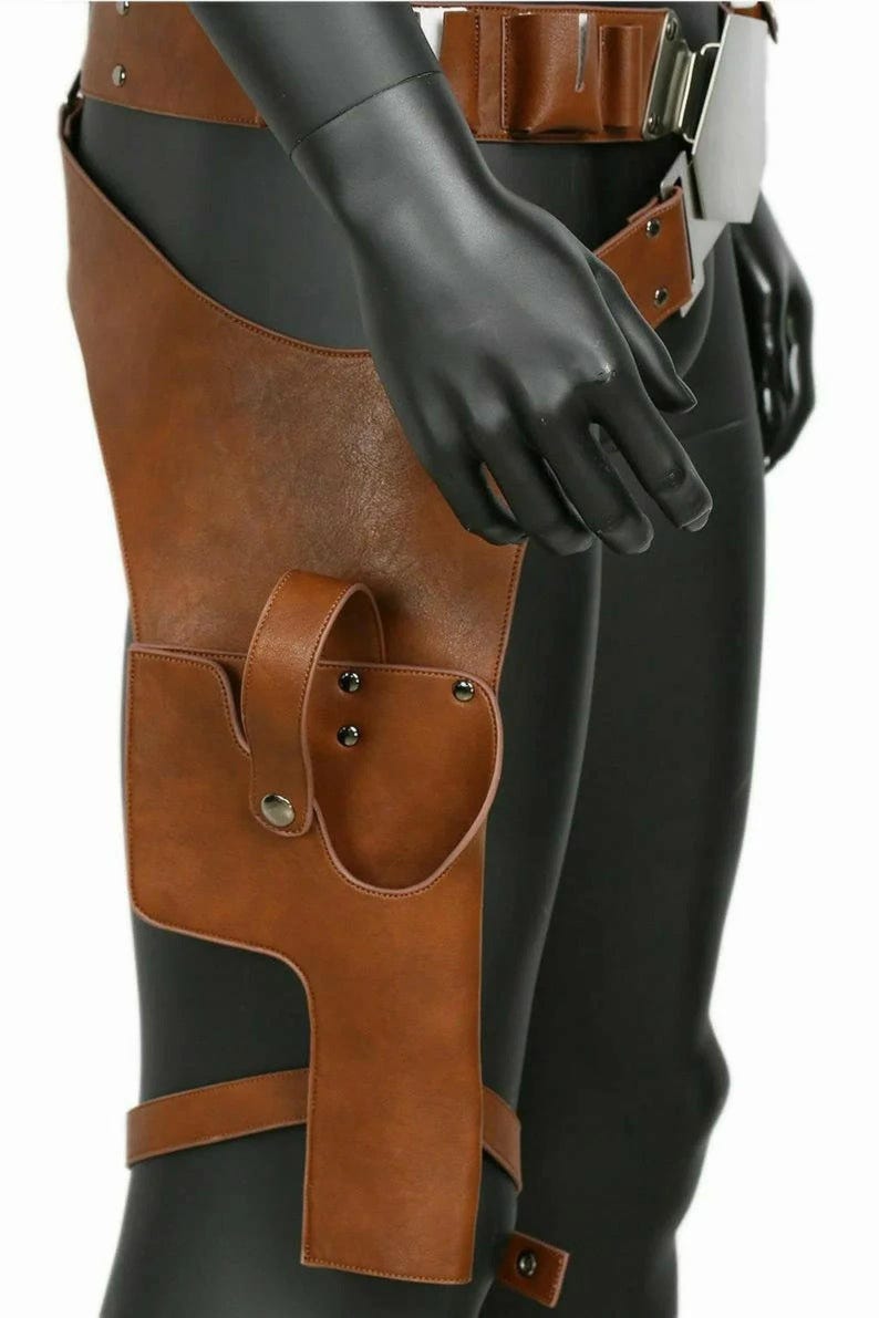 Op de afbeelding: Een bruine kunstlederen dijbeenholster met een brede riem met metalen gesp, een veiligheidsriem met drukknoopsluiting en een verstelbare beenband. De holster is afgewerkt met zichtbare stiksels en zilverkleurige metalen klinknagels.