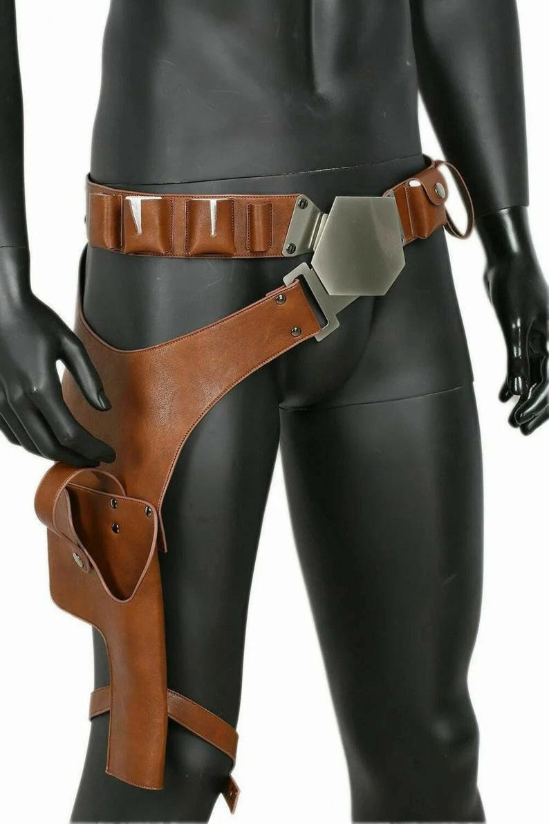 Op de afbeelding: Een bruine utility-riem van kunstleer met een grote zeshoekige metalen gesp en een bijpassende holster voor aan het been. De riem bevat ge&iuml;ntegreerde zakjes langs de tailleband en een extra beenband om de holster op zijn plek te houden.