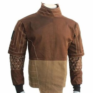 May include: A brown jacket with a high collar and white stitching details. The jacket features a two-tone design, with a lighter brown lower section and geometric patterns on the sleeves. Black cuffs complete the look.